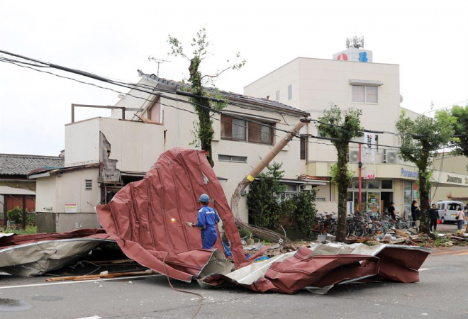 Um trabalhador está em cima de um grande entulho carregado por ventos fortes gerados pelo tufão Shanshan em Miyazaki, ilha de Kyushu, sudoeste do Japão, 29 de agosto de 2024. O poderoso tufão Shanshan atingiu a ilha principal de Kyushu, no sudoeste do Japão. A Agência Meteorológica do Japão e os governos locais emitiram alertas de desastres naturais, enquanto as operadoras de transporte cancelaram trens e voos para a ilha principal do sudoeste.