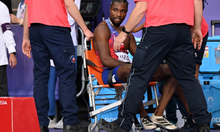 O medalhista de bronze norte-americano Noah Lyles (C) recebe atendimento médico após competir na final dos 200m masculinos do evento de atletismo dos Jogos Olímpicos de Paris 2024, no Stade de France, em Saint-Denis, ao norte de Paris, em 8 de agosto de 2024.