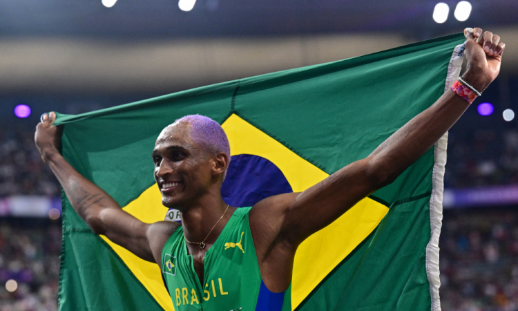 O brasileiro Alison Dos Santos, terceira colocada, comemora após a final dos 400m com barreiras masculinos do evento de atletismo dos Jogos Olímpicos de Paris 2024, no Stade de France, em Saint-Denis, ao norte de Paris, em 9 de agosto de 2024.