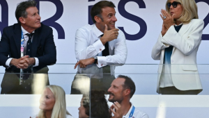 O presidente mundial do atletismo, Sebastian Coe (L), o presidente da França, Emmanuel Macron (C) e sua esposa Brigitte Macron (R), reagem enquanto assistem à final feminina dos 100m com barreiras do evento de atletismo nos Jogos Olímpicos de Paris 2024, no Stade de France, em Saint- Denis, ao norte de Paris, em 10 de agosto de 2024.