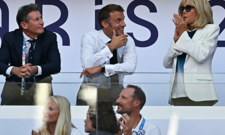 O presidente mundial do atletismo, Sebastian Coe (L), o presidente da França, Emmanuel Macron (C) e sua esposa Brigitte Macron (R), reagem enquanto assistem à final feminina dos 100m com barreiras do evento de atletismo nos Jogos Olímpicos de Paris 2024, no Stade de France, em Saint- Denis, ao norte de Paris, em 10 de agosto de 2024.