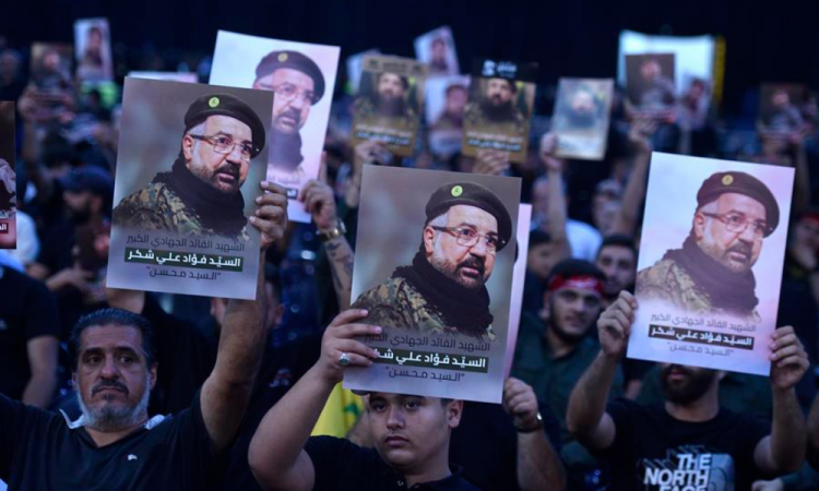 Pessoas em luto seguram fotos enquanto comparecem ao cortejo fúnebre do falecido comandante do Hezbollah, Fuad Shukr, morto em um ataque israelense, em Beirute, Líbano, em 1º de agosto de 2024. O Hezbollah e as Forças de Defesa de Israel (IDF) confirmaram que Shukr foi morto em um ataque israelense em 30 de julho, no bairro Haret Hreik, em Beirute. A mídia estatal do Líbano disse que pelo menos quatro pessoas foram mortas