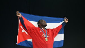 O medalhista de ouro cubano Mijain Lopez Nunez posa com a bandeira cubana e sua medalha após a cerimônia de apresentação do evento de luta livre masculina greco-romana até 130 kg na Arena Champ-de-Mars durante os Jogos Olímpicos de Paris 2024, em Paris,