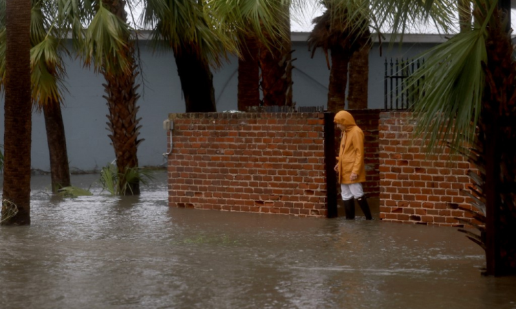 Uma pessoa caminha por uma rua inundada causada pela chuva e tempestade do furacão Debby em 5 de agosto de 2024, em Cedar Key, Flórida.