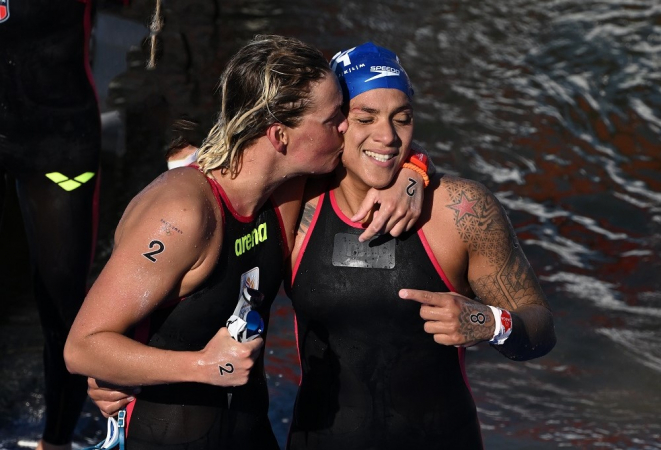 A vencedora da medalha de ouro Sharon Van Rouwendaal (e), da Holanda, comemora com a brasileira Ana Marcela Cunha (d) após cruzarem a linha de chegada