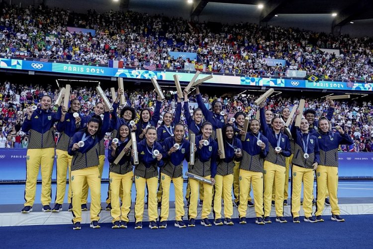 Seleção brasileira feminina de futebol festeja a medalha de prata no pódio, apesar da derrota para os EUA