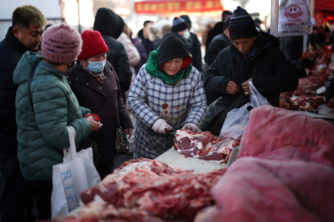 Vendedor cortando carne para clientes em um mercado em Shenyang, na província de Liaoning, no nordeste da China