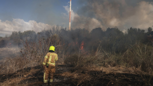 Um socorrista apaga um incêndio em um campo aberto em Lod, perto de Tel Aviv, supostamente causado por um míssil disparado do Iêmen