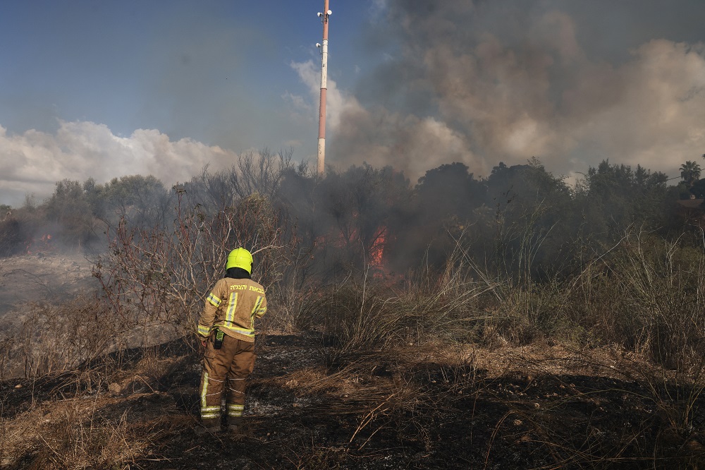 Um socorrista apaga um incêndio em um campo aberto em Lod, perto de Tel Aviv, supostamente causado por um míssil disparado do Iêmen