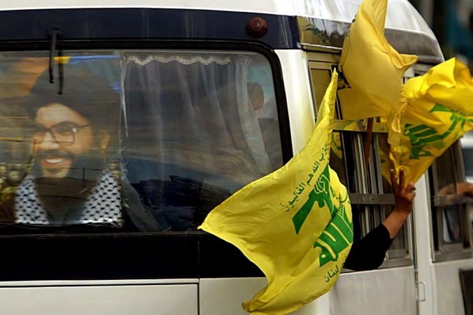 (FILES) A poster of Hezbollah leader Hassan Nasrallah and flags of the group decorate a bus heading to the southern suburb of Beirut on February, 22 2006 to attend a massive 