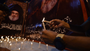 Manifestantes acendem velas em frente a fotos do falecido líder do Hezbollah, Hassan Nasrallah, durante um protesto anti-Israel após a morte de Nasrallah, em Carachi, Paquistão