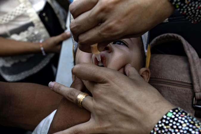 Uma enfermeira administra gotas de vacina contra a poliomielite em crianças palestinas em uma escola da ONU no campo de Khan Yunis, no sul da Faixa de Gaza, em 05 de setembro de 2024. De acordo com a Diretora Regional da UNICEF para o Oriente Médio e Norte da África, Adele Khodr, a primeira fase de uma campanha de vacinação contra a poliomielite de duas rodadas, de 01 a 03 de setembro, superou sua meta inicial (estimada em 157.000 crianças devido ao movimento populacional) e atingiu mais de 189.000 crianças menores de 10 anos na Faixa de Gaza central. O lançamento da próxima fase da campanha ocorrerá no sul de Gaza de 05 a 08 de setembro de 2024, atingindo cerca de 340.000 crianças menores de 10 anos, disse a Organização Mundial da Saúde (OMS). Para evitar a disseminação da variante circulante do poliovírus tipo 2 (cVDPV2), uma campanha de vacinação contra a poliomielite com a nova vacina oral contra o poliovírus tipo 2 (nOPV2) foi lançada no enclave palestino depois que a OMS e a UNICEF pediram pausas humanitárias no conflito para permitir a vacinação após a descoberta do poliovírus em amostras ambientais de Khan Yunis e Deir Al Balah em julho de 2024.