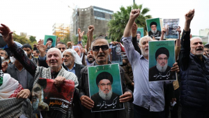 Manifestantes seguram fotos do falecido líder do Hezbollah, Hassan Nasrallah, durante um protesto anti-Israel na Praça Palestina, em Teerã