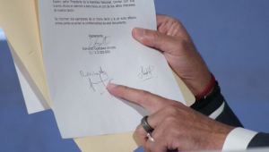 Fotografia cedida pela assessoria de imprensa da Assembleia Nacional que mostra o presidente da entidade, Jorge Rodriguez, apontando para um documento durante entrevista coletiva, nesta quarta-feira, em Caracas (Venezuela). O presidente da Assembleia Nacional (AN, Parlamento) da Venezuela, Jorge Rodríguez, mostrou esta quarta-feira uma "carta assinada" pelo porta-estandarte da oposição maioritária, Edmundo González Urrutia, na qual afirma acatar a decisão do Supremo Tribunal de Justiça (TSJ) para validar a polémica vitória de Nicolás Maduro nas eleições de 28 de julho.