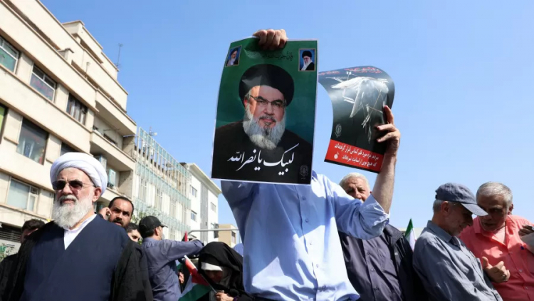 um-homem-levanta-uma-foto-do-chefe-do-hezbollah-hasan-nasrallah-durante-um-protesto-em-teera-1727471