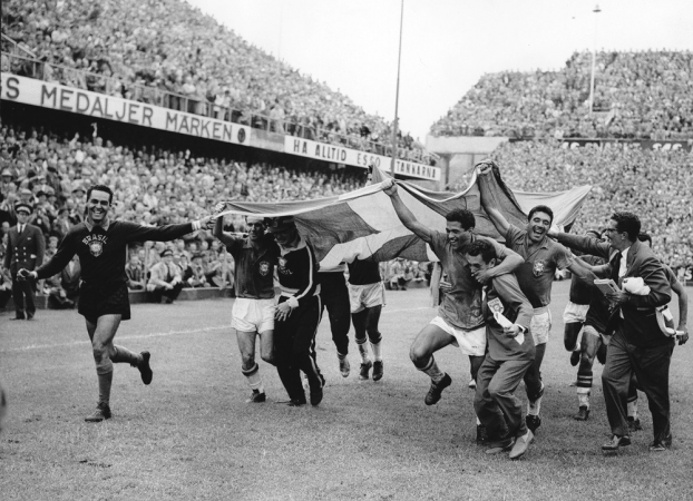 Jogadores do Brasil comemoram carregando a bandeira da Suécia em homenagem ao país sede, após vencer a final da Copa de 58