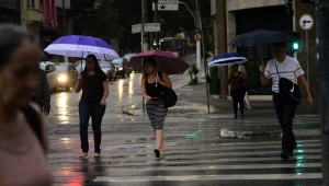 Pedestres enfrentam chuva na região central da cidade de São Paulo