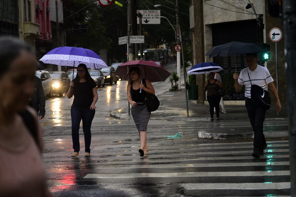 Pedestres enfrentam chuva na região central da cidade de São Paulo