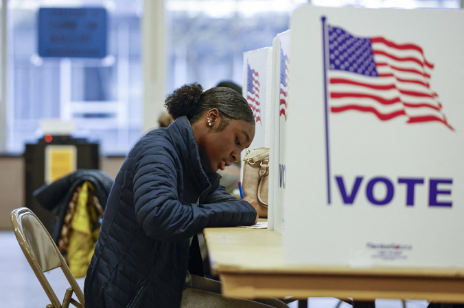 mulher vota durante a votação antecipada para a eleição geral dos EUA em uma seção eleitoral na Ottawa Hills High School em Grand Rapids, Michigan