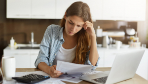 Mulher jovem verificando seu orçamento e pagando impostos