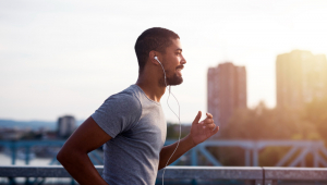 Esportista com fones de ouvido correndo e curtindo