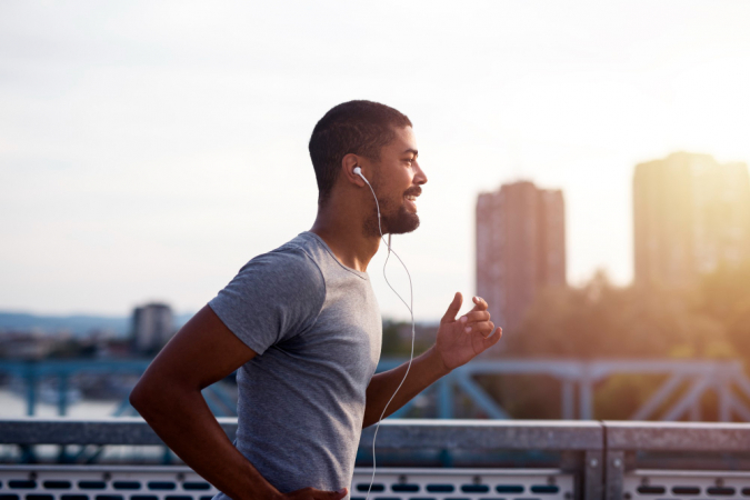 Sportivo con le cuffie che corre e si diverte