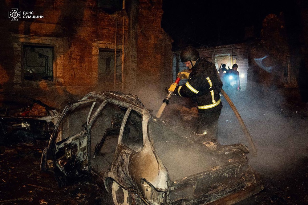 Bombeiros ucranianos trabalhando no local de uma área residencial atingida por um ataque aéreo russo em Sumy, no nordeste da Ucrânia,