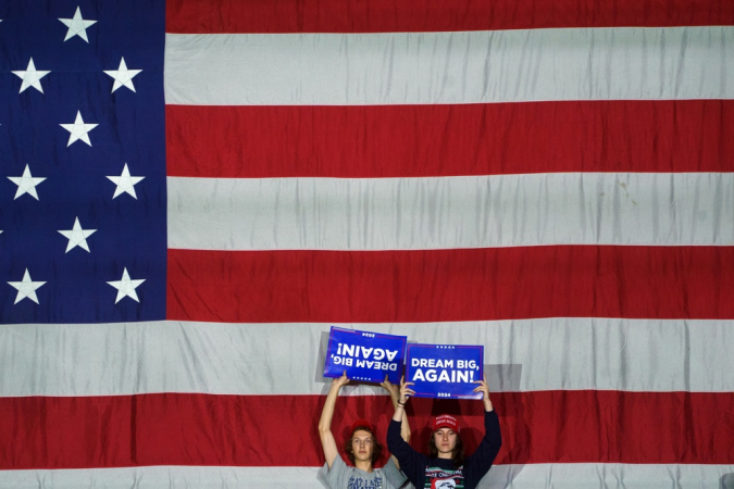 Simpatizantes do ex-presidente dos Estados Unidos, Donald Trump, seguram cartazes durante um comício nesta segunda-feira, em Reading, Pensilvânia