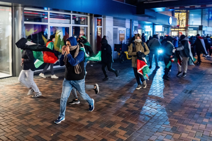 Manifestantes correm com bandeiras palestinas antes da partida da Liga Europa da UEFA entre Ajax e Maccabi Tel Aviv