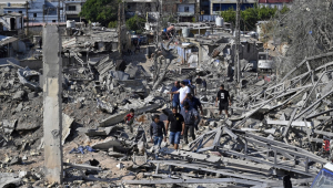 Pessoas inspecionam os danos no local de um ataque aéreo israelense na área de Ouzai, perto da pista do Aeroporto de Beirute, no sul da capital libanesa