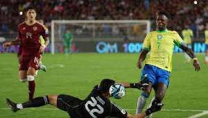 Rafael Romo (abaixo), da Venezuela, disputa a bola com Vinícius Jr., do Brasil, nesta quinta-feira, durante uma partida das eliminatórias sul-americanas