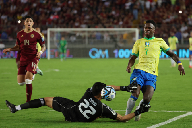 Rafael Romo (abaixo), da Venezuela, disputa a bola com Vinícius Jr., do Brasil, nesta quinta-feira, durante uma partida das eliminatórias sul-americanas