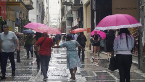 Pedestres se protegem da chuva na região central de São Paulo