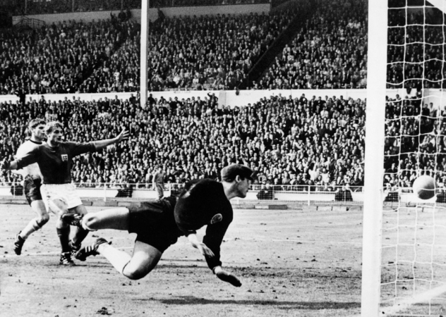 O goleiro da Alemanha Ocidental, Hans Tilkowski, observa a bola bater no travessão após um chute do atacante inglês Geoff Hurst (não visível na foto)