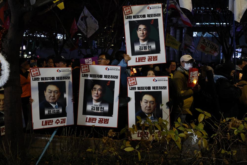 Integrantes de grupos civis e da Confederação Coreana de Sindicatos (KCTU) realizam manifestação com velas e cartazes pedindo a prisão do presidente Yoon Suk Yeol e do ex-ministro da Defesa Kim Yong-hyun