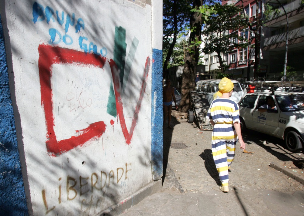 Popular passa diante de muro pichado com as iniciais do Comando Vermelho