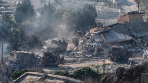 Blindados do exército israelense se movem entre casas destruídas na aldeia de Meiss El-Jabal, no sul do Líbano, enquanto deixam o território libanês