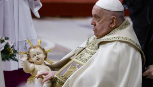 O Papa Francisco segura uma estátua do Menino Jesus durante a Missa da Noite de Natal na Basílica de São Pedro, na Cidade do Vaticano