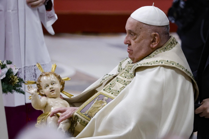 O Papa Francisco segura uma estátua do Menino Jesus durante a Missa da Noite de Natal na Basílica de São Pedro, na Cidade do Vaticano