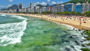 Turistas e banhistas aproveitam dia de sol na Praia de Copacabana, na zona sul de Rio de Janeiro