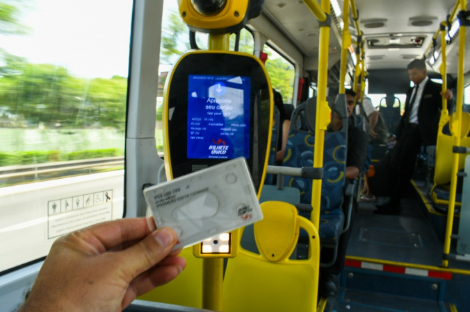 Pessoa passa bilhete único no ônibus