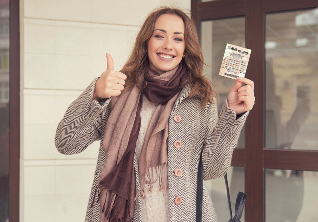 Mulher com bilhete de loteria na mão