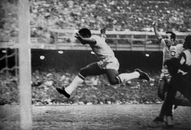 Pelé aproveita o rebote do goleiro paraguaio e marca o único gol da partida entre Brasil e Paraguai, no estádio do Maracanã, pelas Eliminatórias para a Copa do Mundo no México