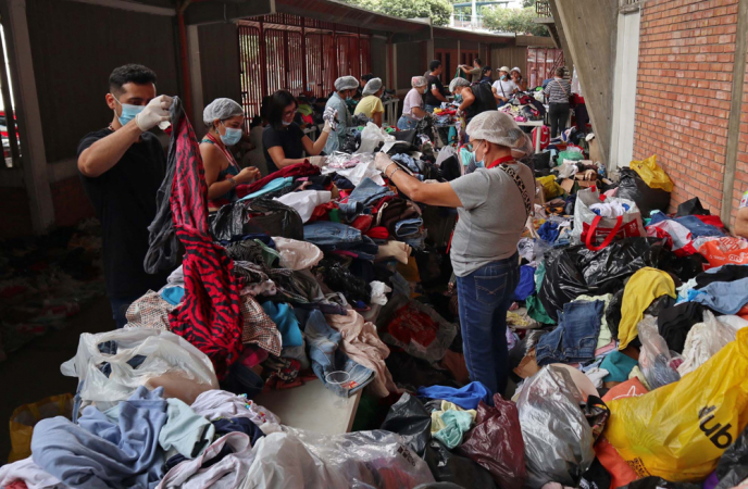 Le persone smistano alcuni vestiti donati agli sfollati a causa della violenza a Catatumbo