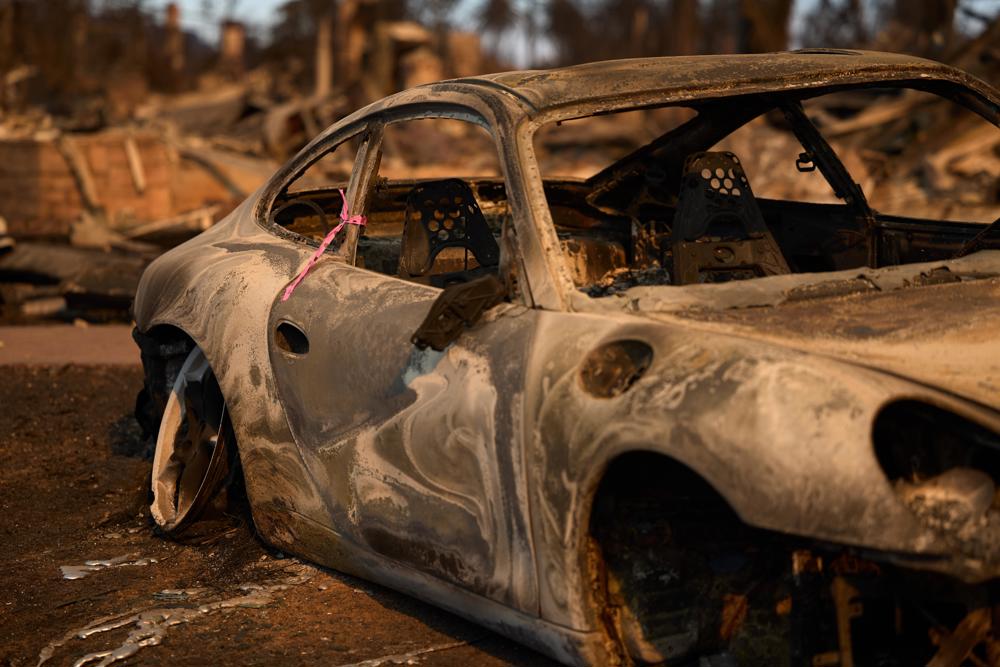 carro está marcado com uma fita rosa, indicando que foi inspecionado pelos bombeiros durante o incêndio florestal em Palisades, no bairro de Pacific Palisades, em Los Angeles