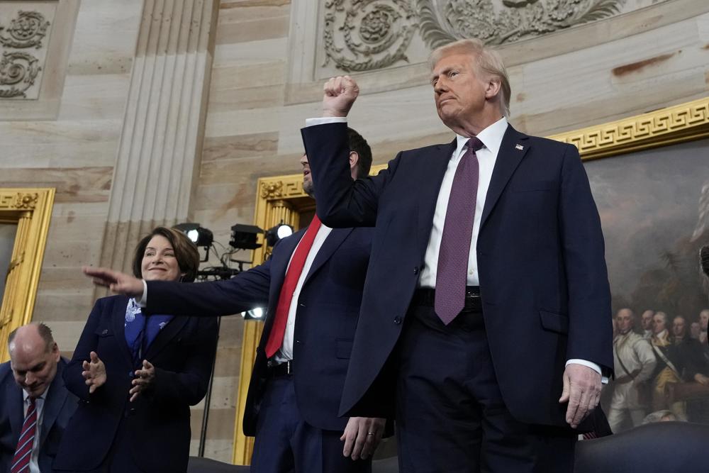 O presidente Donald Trump, ao centro, gesticula enquanto é acompanhado no palco pelo vice-presidente JD Vance após tomar posse como o 47º presidente dos Estados Unidos