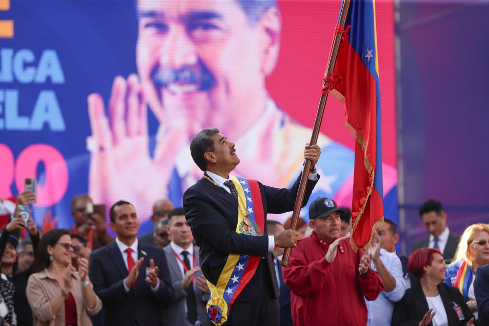 O líder chavista Nicolás Maduro agita uma bandeira em um ato nesta sexta-feira, em Caracas