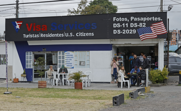 Cidadãos colombianos solicitantes de visto para os Estados Unidos caminham em frente à embaixada americana
