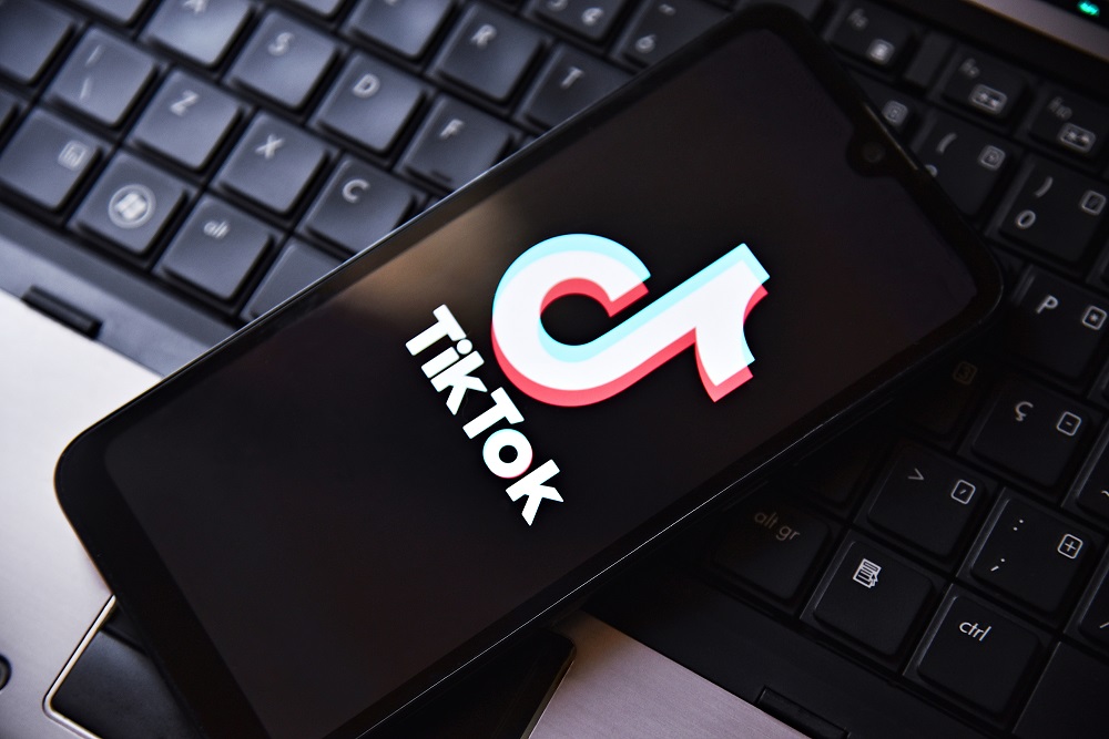 Celular com logo do TikTok em cima de teclado de notebook