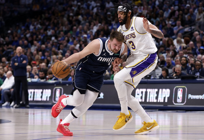 Luka Doncic (#77) do Dallas Mavericks controla a bola contra Anthony Davis (#3) do Los Angeles Lakers no primeiro tempo da partida no American Airlines Center, em 26 de fevereiro de 2023